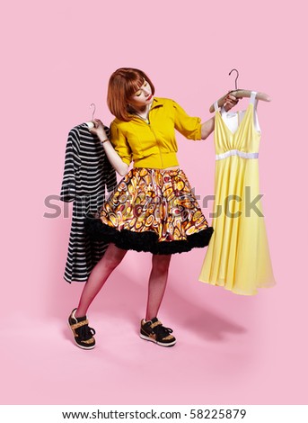 portrait of redhead woman choosing one of two dresses