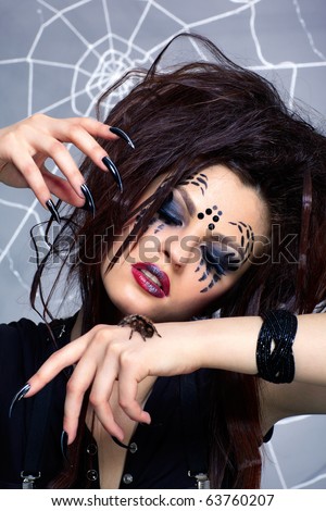 portrait of girl with spider bodyart of face zone with real spider Brachypelma smithi on her hand