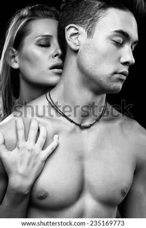 Young couple in love on black background