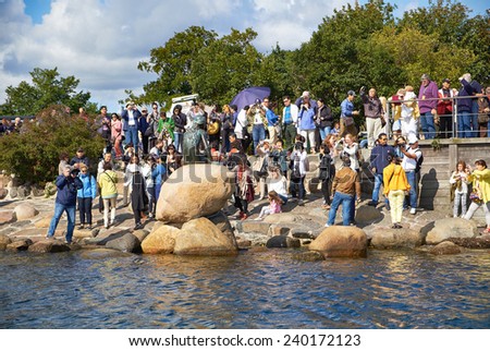 COPENHAGEN, DENMARK - AUGUST 22, 2014: Group of tourists near Little Mermaid statue. The monument of Little Mermaid is one of the biggest tourist attractions in Copenhagen and Denmark