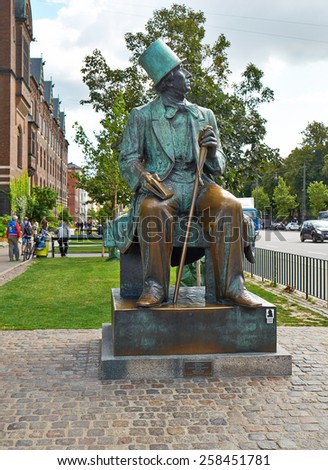 COPENHAGEN, DENMARK - AUGUST 22, 2014:  Statue of Hans Christian Andersen looking across Boulevard to Tivoli Gardens in Copenhagen, Denmark.  Statue made by sculptor Henry Luckow-Nielsen in 1961.