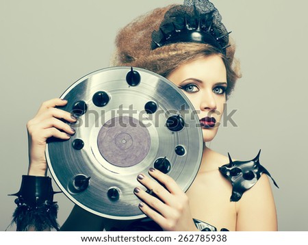 Woman in dress and diadem made of molten vinyl disk with record in hands