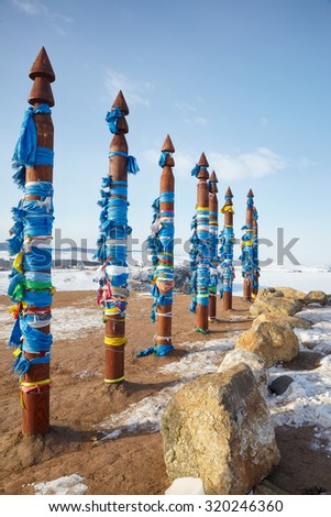 Wooden shaman totems with ribbons near holy cape Burkhan on island Olkhon on lake Baikal in Siberia