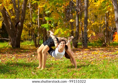 Man and woman practice Yoga dhanurasana under urdhva dhanurasana pose in forest