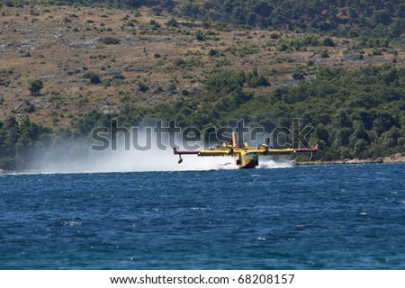 GREBASTICA, CROATIA - JULY 7: Canader takes water to put out fire on July 7, 2010 in Grebastica, Croatia