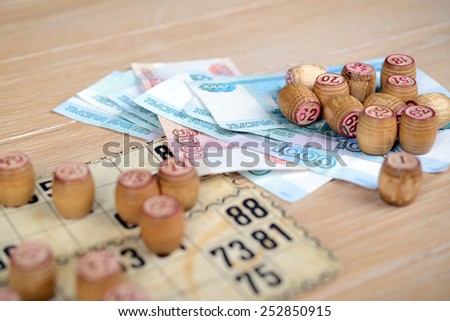 bingo (lotto) kegs and cards with rubles on the wooden table. Retro, vintage.