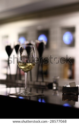 A white wine glass in a club, half filled