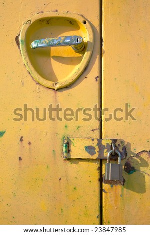 Bright yellow metal door with handle and padlock