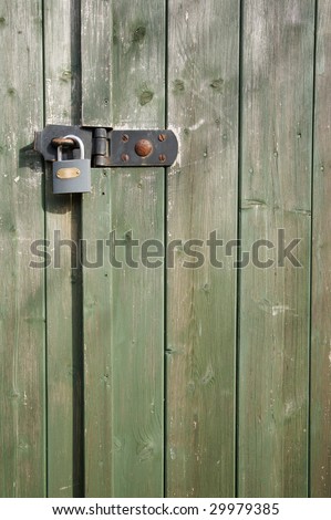 A padlocked shed door with light and shadow falling on it