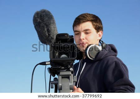 Young man filming video outside