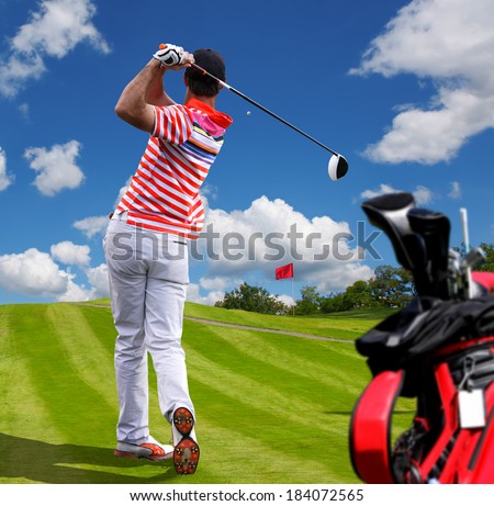 Man playing golf against blue sky with golf bag
