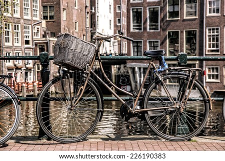 Amsterdam with old bicycle on the bridge against canal in  Holland