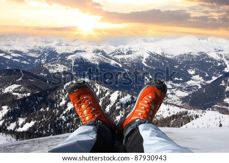 Winter shoes against sunset over the Alps