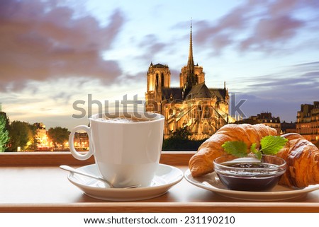 Coffee with croissants against cathedral Notre Dame in Paris, France