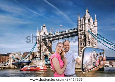 Tourist couple taking selfie against Tower Bridge in London, England, UK