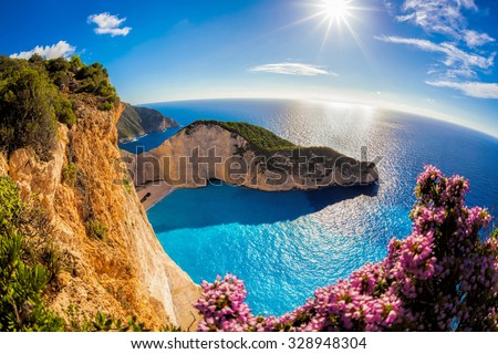 Navagio beach with shipwreck and flowers against sunset in Greece