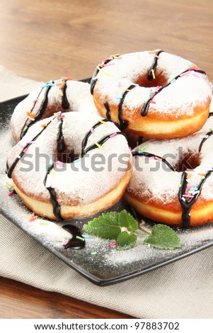 Fresh dough-nuts with icing sugar and chocolate
