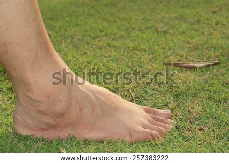 man's foot on grass background