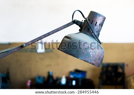Red old metal lamp with rusty and dusty in factory
