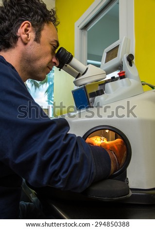 operator man working on a laser equipment for the production of dental prostheses