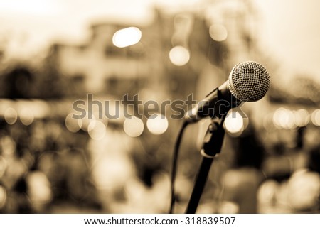Close up of microphone in concert or conference room with blur people in the background. Retro Style