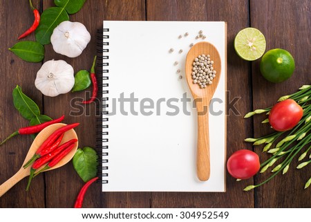 Recipe notebook, rice, Red chilli, garlic and lemon on wood texture background