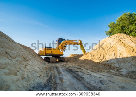 excavator machine loading dumper truck at sand