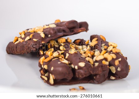 Tasty bananas covered by chocolate and nuts