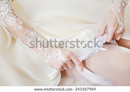 the bride wears a wedding garter on the leg