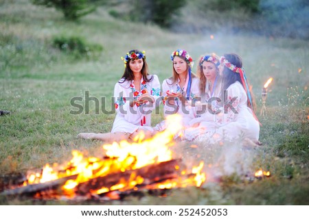 Ukrainian girl in shirts sitting around the campfire