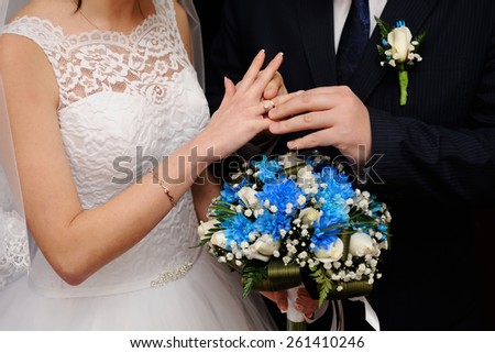 bride groom wears a wedding ring on the finger