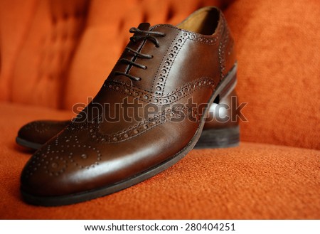 Brown man\'s shoes brogues on an orange background