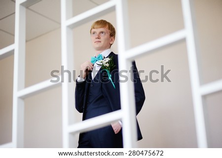 groom straightens his bow tie mint