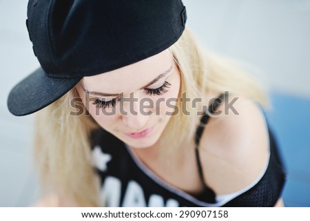 young girl with long eyelashes in a baseball cap and a T-shirt hip-hop style