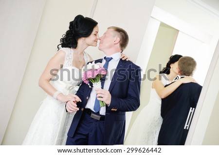 bride and groom kissing on the background of mirrors
