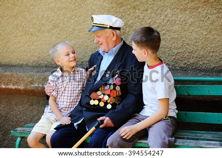 WWII veteran with children. Grandchildren looking at grandfather\'s military awards.