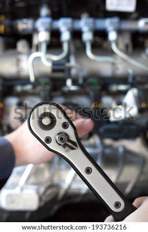 Hand with wrench. Auto mechanic in car repair. Selective focus