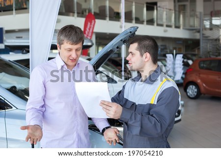 An angry customer talking to a mechanic in an auto repair shop