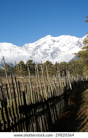 mountain landscape with old fence fence and snowy mountains