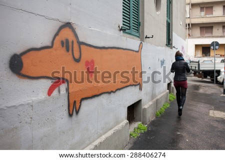 ROME, ITALY - JANUARY, 2015: Woman walking by a dog painted on a wall by street artist.
