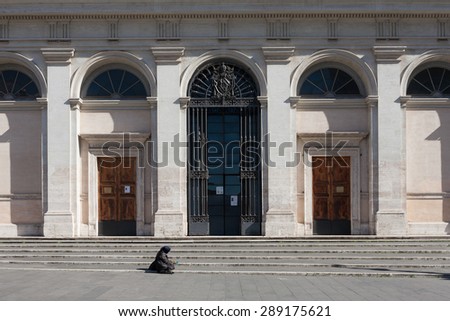 ROME, ITALY - FEBRUARY, 2014 - Woman asking for money in front of a church in Piazza San Giovanni.