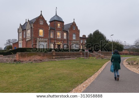 READING, UK - CIRCA MARCH 2015: A student walks near the Old Whiteknights House,  a modernised Victorian building which hosts the Graduate School of University of Reading.