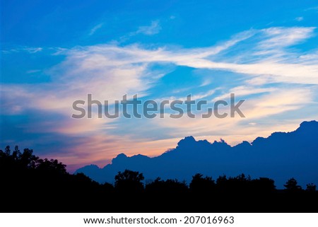 Colorful landscape with great blue cloud,evening sky and silhouette of trees