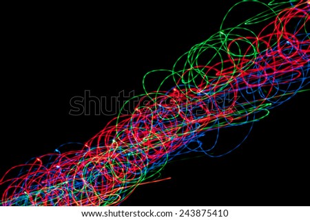 Abstract images as interwoven multicolored light lines on a black background