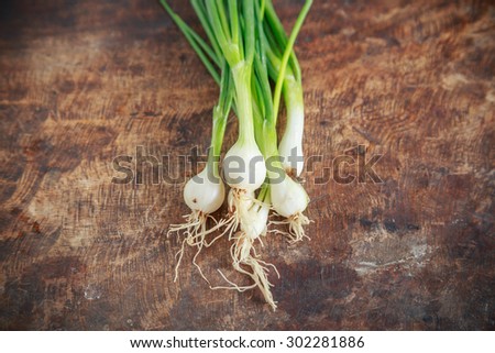 bunch of spring onions on wooden background
