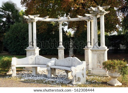 Stone bench and columns centre a peaceful Mediterranean garden