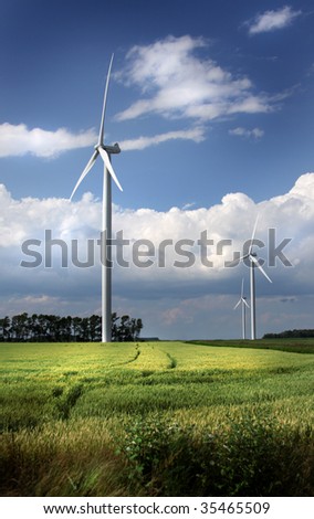 Several power-generating windmills in a field.