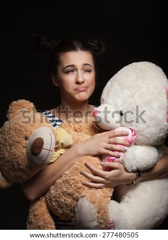 portrait of attractive caucasian smiling woman brunette with bear isolated on black studio shot