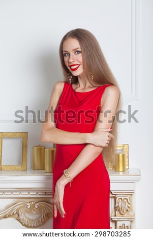 Beautiful brunette woman in a red dress. Studio shot. Long hair. Red lips.