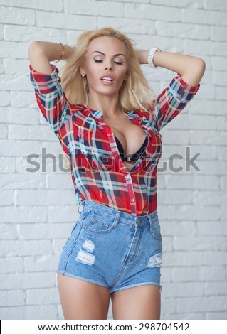 Sexy blond girl in a red  top and denim shorts. Big boobs.